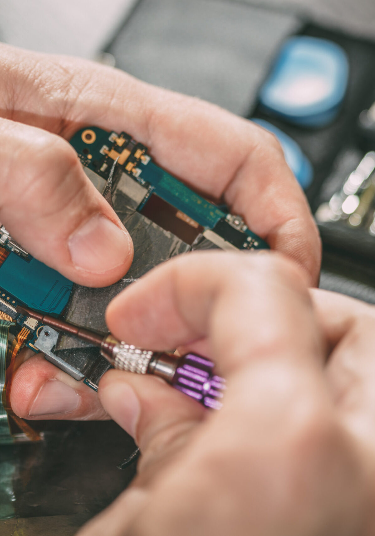 Close-up of a male hands servising broken smartphone.