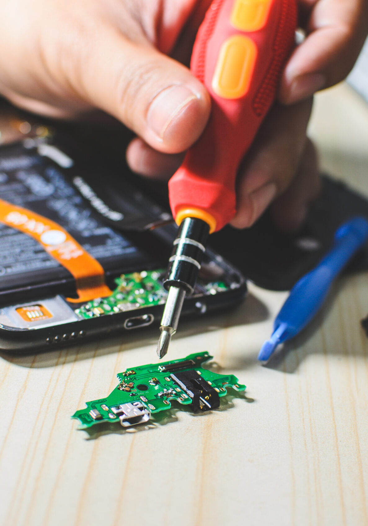 man is repairing a mobile phone.